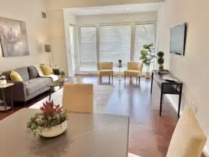 Living room in residence 648 with a sofa, armchairs and wall-mounted television
