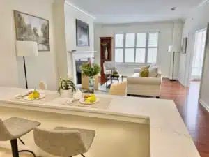 a condo living room with a kitchen bar seating and a couch with a fireplace