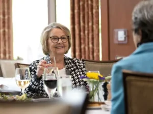 Fox Hill condominium owner enjoying a meal with a friend in the community dining room